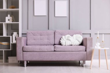 İçeride yastıkları olan rahat gri bir kanepe. İç tasarım