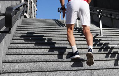 Spor ayakkabılı bir adam merdivenlerde koşuyor, yakın plan. Metin için boşluk
