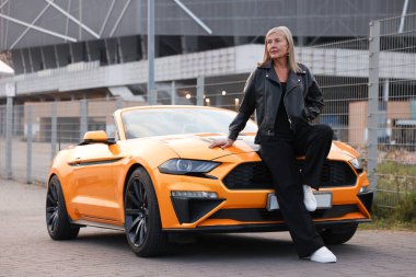 Modern Cabriolet yakınlarında şık bir son sınıf öğrencisi.