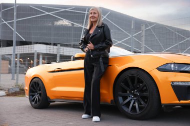 Modern Cabriolet yakınlarında şık bir son sınıf öğrencisi.