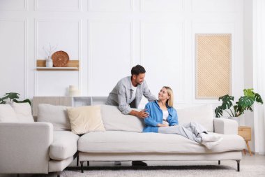 Mutlu çift evdeki kanepede birlikte vakit geçiriyor.