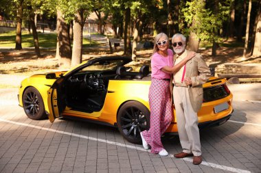 Modern Cabriolet yakınlarında güneş gözlüklü şık bir çift.