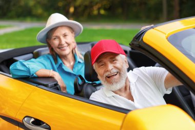 Üst düzey bir çift açık havada eğleniyor, seçici bir odak noktası var.