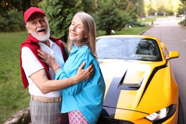 Modern Cabriolet yakınlarında şık bir yaşlı çift.