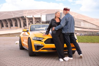 Modern Cabriolet yakınlarında şık bir yaşlı çift.