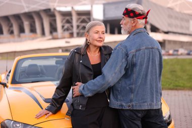 Modern Cabriolet yakınlarında şık bir yaşlı çift.