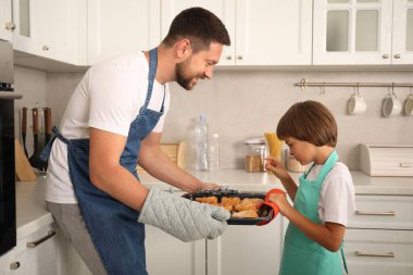 Baba ve oğul mutfakta hamur işi pişiriyor.