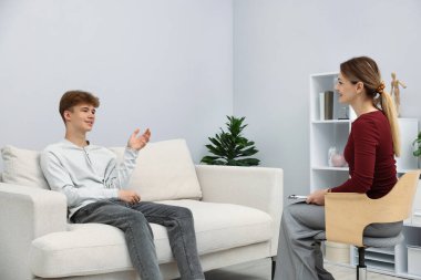 Ofiste genç bir çocukla çalışan profesyonel psikolog.