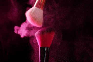 Siyah arka planda pembe göz farlı makyaj fırçaları, yakın plan