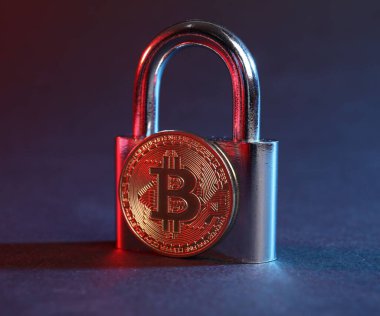 Bitcoin ve asma kilit mavi arkaplanda kırmızı ışıkta, yakın plan