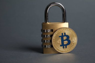 Bitcoin ve asma kilit gri arka planda, yakın plan. Metin için boşluk