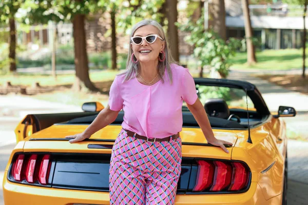 Modern Cabriolet yakınlarında güneş gözlüklü şık bir son sınıf öğrencisi.