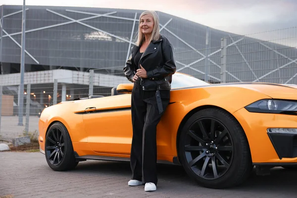 Modern Cabriolet yakınlarında şık bir son sınıf öğrencisi.