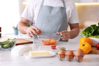 İçerideki mermer masada yemek pişiren adam, yakın plan.