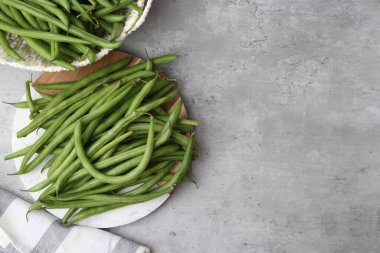 Taze yeşil fasulye kabukları gri masada, düz yerde. Metin için boşluk