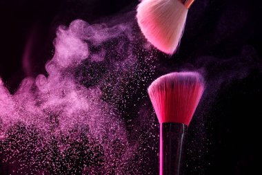 Siyah arka planda pembe göz farlı makyaj fırçaları, yakın plan. Metin için boşluk