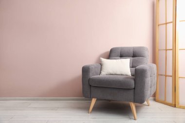 İçerideki bej duvarın yanında rahat bir koltuk ve yastık. Metin için boşluk