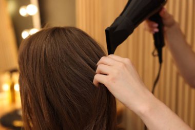 Kuaför kuaför kuaförde müşterinin saçını kurutuyor.