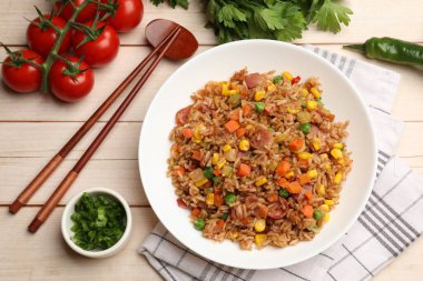 Lezzetli kızarmış pirinç, ürünler ve yemek çubukları açık ahşap masa, düz uzanma