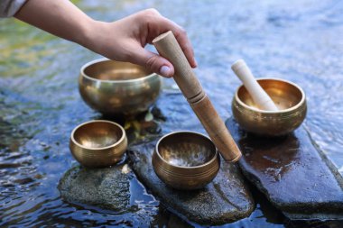 Nehir kenarında kaseleri olan kadın, yakın plan.