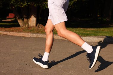 Güneşli bir günde şık spor ayakkabılı bir adam, yakın plan.