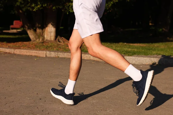 Güneşli bir günde şık spor ayakkabılı bir adam, yakın plan.