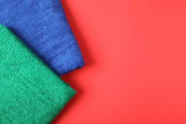 Kırmızı arka planda parlak havlular, üst manzara. Metin için boşluk