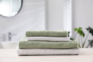 Katlanmış havlular banyodaki açık ahşap masada, yakın plan.