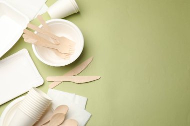 Zeytin arka planda tek kullanımlık sofra takımı, düz konum. Metin için boşluk