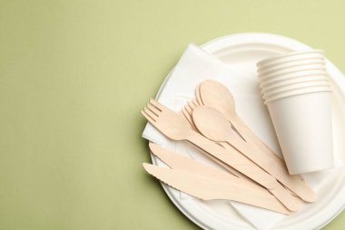 Zeytin arka planda tek kullanımlık sofra takımı, üst görünüm. Metin için boşluk