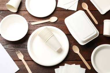 Tek kullanımlık sofra takımı ve peçeteler ahşap masada, düz yatıyordu.