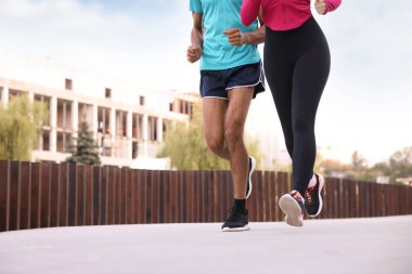 Spor giyimli bir çift dışarı koşuyor, yakın plan. Metin için boşluk