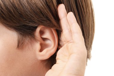 Ses geliyor. Beyaz arka planda el ele hareketler gösteren çocuk, yakın plan.