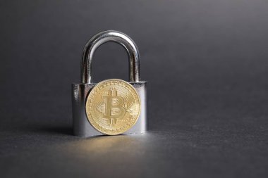 Bitcoin ve asma kilit gri arka planda, yakın plan. Metin için boşluk