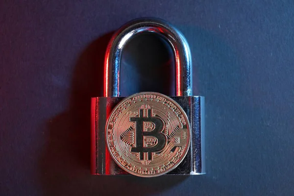 Bitcoin ve asma kilit mavi arkaplanda kırmızı ışıkta, üst görünümde