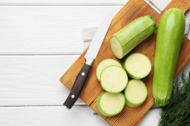 Taze olgun kabaklar ve beyaz ahşap masada düz bir şekilde duran bıçak. Metin için boşluk