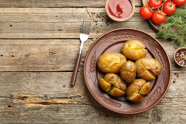 Lezzetli fırında patates, çatal, baharat ve ürünler ahşap masada, düz yerde. Metin için boşluk