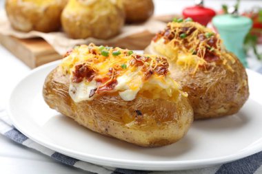 Lezzetli fırında patatesler beyaz masada, yakın plan.