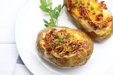 Beyaz ahşap masada lezzetli fırında patatesler, yakın plan.