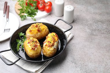 Gri masada servis edilen fırında patatesler, yazı için yer var.