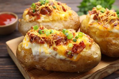 Tahta masada servis edilen lezzetli fırınlanmış patatesler, yakın plan.