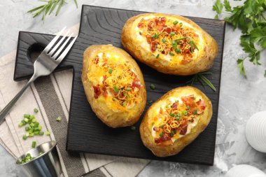 Gri desenli masada servis edilen lezzetli fırınlanmış patatesler.