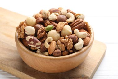 Farklı fındıkların karışımı beyaz ahşap masada, yakın plan