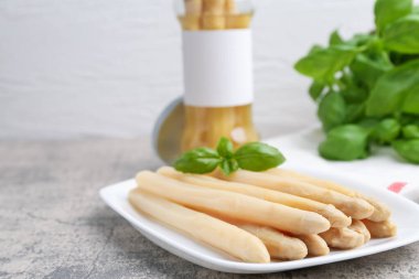 Gri masadaki fesleğenli kuşkonmaz mızrakları yakın plan.