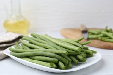 Fresh green bean pods on white table, closeup