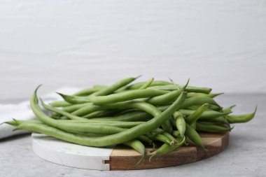Fresh green bean pods on grey table, closeup