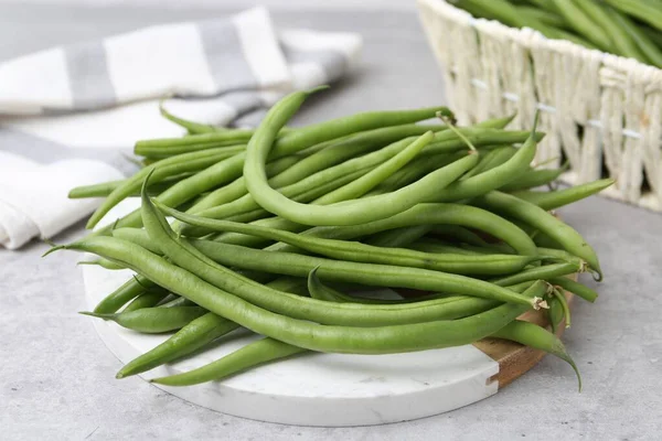 Fresh green bean pods on grey table, closeup