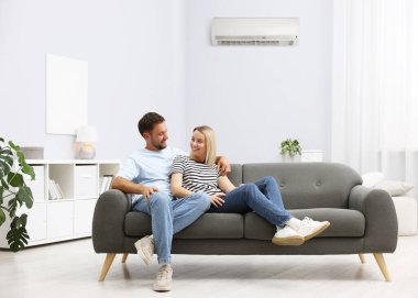 Mutlu çift, klimalı kanepede birlikte vakit geçiriyor.