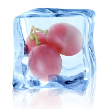Beyaz zemin üzerinde buz küpünün içindeki taze üzümler
