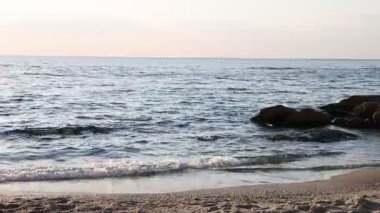 Güzel dalgalı deniz, taşlar ve kumlu sahil